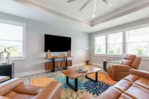 Modern living room with leather couches and a large TV on the wall.