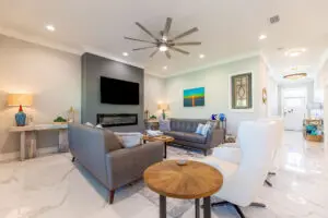 Modern living room with gray sofas and a large ceiling fan.