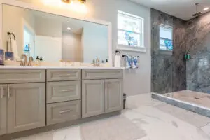 Modern bathroom with dual sinks and glass shower.