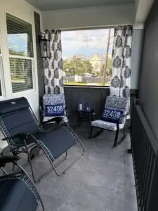 Cozy balcony seating with city view and patterned curtains.